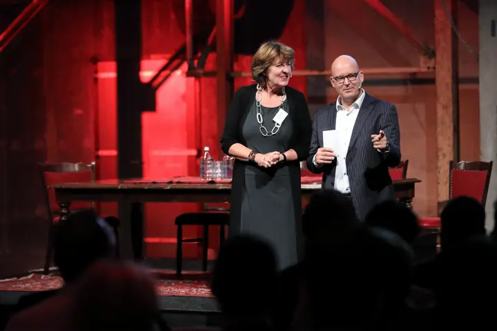 Gert-Jan Jansen en een vrouw op een podium met rode verlichting