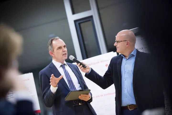 Gert-Jan Jansen houdt een man in pak de microfoon voor