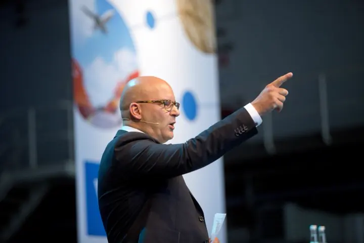 Gert-Jan Jansen wijst vanaf het podium naar de zaal