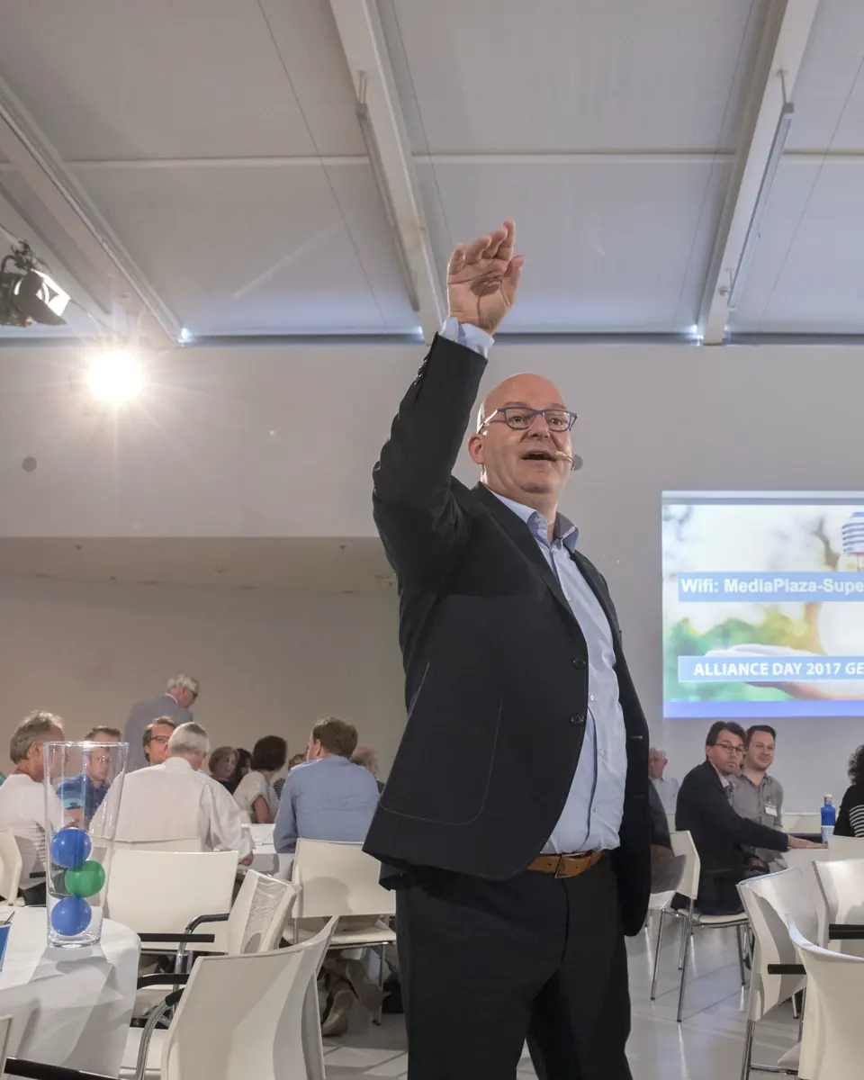 Gert-Jan Jansen steekt zijn arm op en spreekt de zaal toe tijdens de Alliance Day van de universiteiten Utrecht en Eindhoven