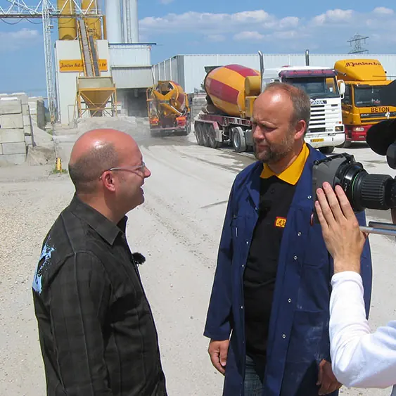 Gert-Jan Jansen interviewt een man bij een betoncentrale voor Omroep Flevoland